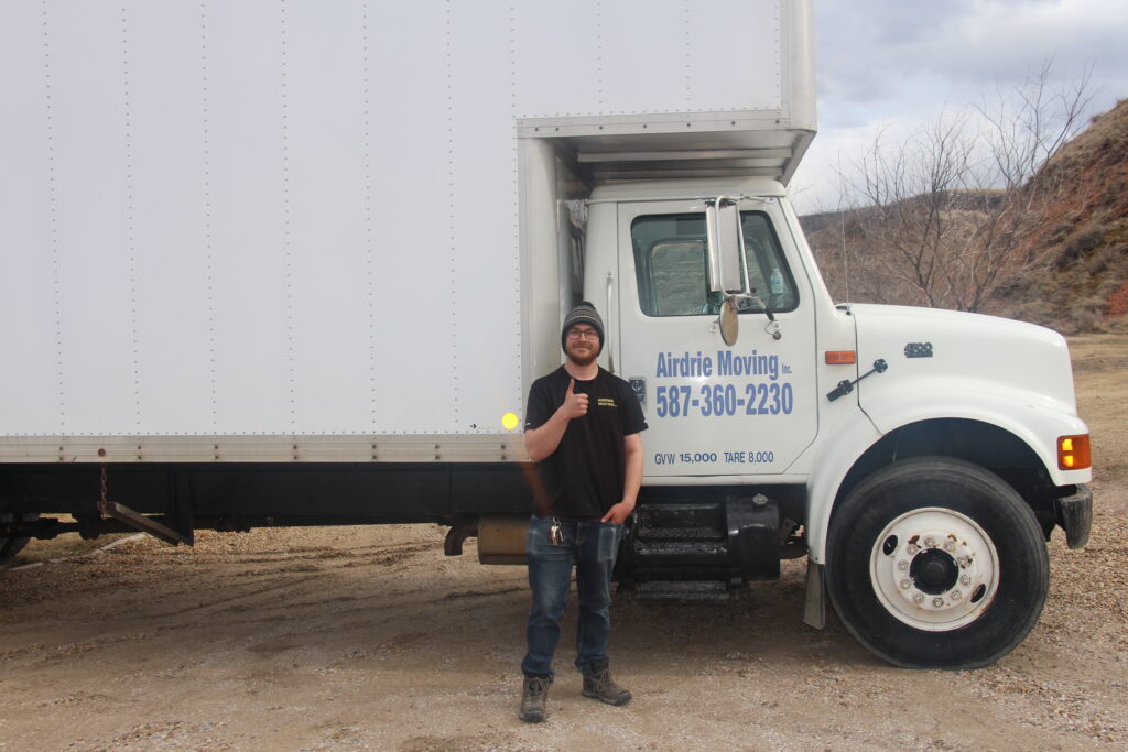 One of the Airdrie movers staff standing beside the truck of the one of the best moving company in airdrie.